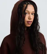 Buzo femenino color blanco crema, confeccionado en algodón y poliéster, con capucha estructurada, bolsillo canguro delantero y puños acanalados.