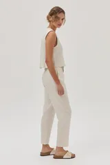 Pantalón chino de lino metalizado color beige, tiro medio-alto y pierna recta. Cuenta con bolsillos laterales y traseros.