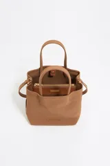 Bolso tote pequeño marca Bimba y Lola, modelo Chihuahua, color marrón. Confeccionado en nylon con estructura blanda, doble asa de mano y asa de tejido, piezas de piel, cierre con botón de presión, logo grabado, acabados metálicos, bolsillo interior e interior con placa metálica logotipada.