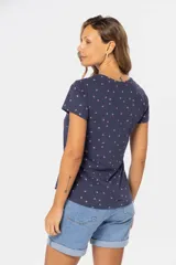 Remera de manga corta color gris claro con estampado de pequeñas figuras geométricas en azul.