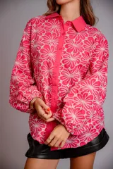 Camisa celeste con estampado de flores blancas, corte clásico, cuello camisero y mangas largas abullonadas.