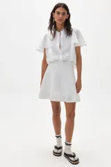 Camisa blanca de lino con mangas cortas acampanadas, cuello mao y botonadura frontal con botones de nácar.