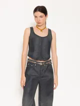 Top estilo corset confeccionado en tejido 100% algodón con proceso de coating simil cuero en tono azulado. Presenta desgastes estratégicos que dejan entrever la base natural, aportando contraste y textura.