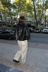 Pantalón de corte recto con estampado de piel de cocodrilo en tonos beige y negro.