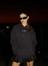 Hoodie negro de corte holgado con capucha y cordón ajustable. Estampado frontal con la leyenda "BE TRENDY EST. 2022" en color rosa.