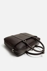 Maletín negro con textura grabada, cierre de cremallera, bolsillo interior para dispositivos electrónicos de hasta 13 pulgadas, bolsillo frontal con cremallera, doble asa de mano y asa de hombro ajustable y extraíble.