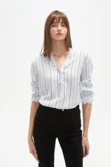Blusa de viscosa con cuello mao y abertura frontal con botones. Presenta un estampado de rayas verticales finas en tonos azul claro, blanco, marrón y azul oscuro.