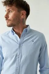 Camisa celeste de manga larga para hombre, con logo bordado y fit slim. Confeccionada en 100% algodón.