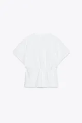 Camiseta color crudo de algodón con cuello redondo, manga corta caída y cintura ajustable con cordón.
