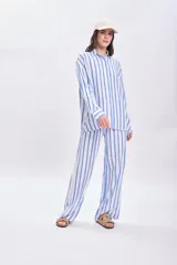 Camisa celeste y blanca a rayas verticales, de corte holgado y manga larga.