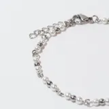 Pulsera plateada con eslabones de cadena y cuentas de perlas sintéticas y acero. Cierre con mosquetón y cadena de alargue.