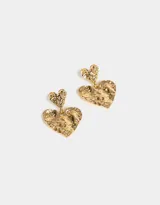 Aros colgantes cortos dorados con dos dijes en forma de corazón con textura martillada.