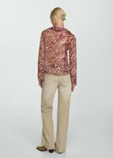 Blusa de manga larga con estampado de hojas y cuello en V con volantes.