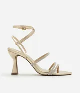 Sandalia dorada de tacón alto con tiras finas y strass.