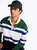 Gorra de béisbol azul marino de Tommy Hilfiger, confeccionada en tejido de espiga de algodón. Presenta diseño de seis paneles, botón en la parte superior, ojales de ventilación, hebilla de ajuste metálica en la parte trasera y logo esmaltado de Tommy en la parte delantera y la hebilla.