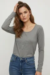 Remera negra de manga larga, confeccionada en algodón y elastano, corte ajustado al cuerpo y cuello redondo.