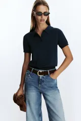 Pantalón de jean azul de corte culotte, tiro alto, pernera ancha y corta. Incluye cinturón marrón de gamuza con hebilla metálica.