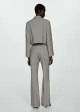 Chaqueta corta gris con cuello camisero, cierre frontal con botones ocultos, dos bolsillos de parche delanteros y forro interior.