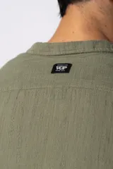 Camisa de lino blanca de manga larga, con cuello clásico y cierre frontal con botones. Corte recto y holgado.