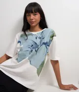 Remera blanca de algodón con cuello redondo y mangas cortas. Estampa frontal con diseño western de caballos y texto "Wild Heart".