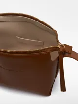 Bandolera pequeña de poliuretano color negro, con correa larga regulable con hebilla metálica y logo grabado.