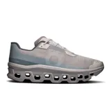 Championes de running On Cloudmonster Void, color gris con detalles en celeste y blanco. Presentan suela con tecnología CloudTec y diseño con perforaciones hexagonales.