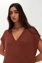 Vestido kaftan corto color terracota, de tejido calado con patrón de esterilla y escote en V.