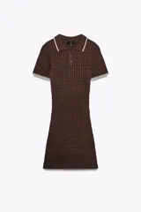 Vestido marrón de punto con cuello polo, manga corta y calce ajustado. Presenta detalle de vivos blancos en cuello y mangas, y botones delanteros.
