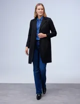 Chaqueta larga símil suede de color negro, con cuello tipo solapa y bolsillos frontales.