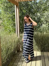 Vestido largo tejido a rayas horizontales azul marino y blancas, sin mangas, con cuello redondo y tajos laterales.