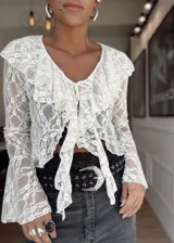 Blusa de encaje blanco con volados en el escote y mangas acampanadas. Se ata en el frente con lazos.