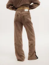 Pantalón de denim verde oliva con efecto gastado, corte recto, tiro medio y botones metálicos en el lateral inferior.