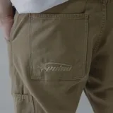 Pantalón de gabardina color marrón con bolsillos laterales y traseros.