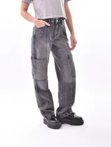 Jean de mezclilla gris oscuro con efecto lavado, corte ancho y tiro alto. Presenta costuras marcadas en el frente y bolsillos cargo a la altura de los muslos.