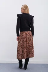 Falda midi plisada con estampado animal print de cebra en tonos beige y marrón. Tiene cintura elástica.