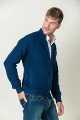 Cárdigan azul de punto con cuello alto, cierre frontal con cremallera y bolsillos laterales.