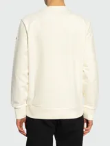 Sudadera color crema de algodón con cuello redondo y logo Moncler bordado en el pecho. Corte clásico con puños y bajo acanalados.