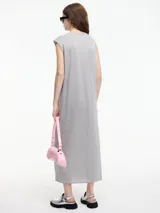 Vestido largo de tejido de punto color crudo, con textura metalizada, cuello escote en V y tajos laterales.