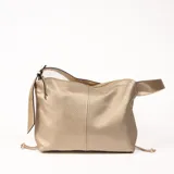 Bolso tipo hobo color beige con textura granulada y correa de hombro ajustable. Cierre superior con cremallera y tiras decorativas laterales con detalle de nudo.