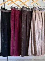 Pantalón ancho de corderoy negro con pliegues marcados en la parte delantera y cintura elástica. Incluye un cinturón negro con hebilla cuadrada.