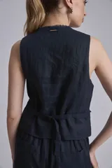 Chaleco azul marino de lino con botones de madera y terminaciones desflecadas.