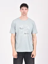 Remera celeste de corte recto con estampado al frente con texto y diseño de aviación en color blanco.