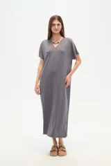 Vestido midi negro de poliéster, corte holgado, manga corta, cuello en V y detalle de cuentas en el escote.