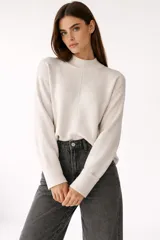 Sweater de viscosa color beige, con cuello polera, corte holgado y pespuntes decorativos en el frente.