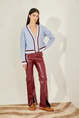 Cardigan celeste de punto trenzado, con escote en V y botones metálicos. Presenta ribetes a contraste en cuello, puños y bajo.