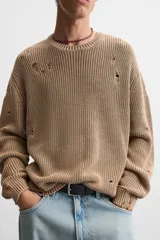 Sweater color marrón claro con efecto lavado ácido y roturas. De corte relajado, cuello redondo y mangas largas.