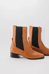 Botas de cuero rojas con elástico negro en los laterales, punta cuadrada y taco bajo.