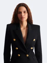 Blazer negro Balmain de corte entallado con doble botonadura y seis botones dorados.