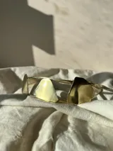 Gargantilla doble plateada con cadena de eslabones y tres piezas irregulares: una color cobre, una plateada y una gris.