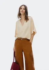 Blusa color crema con escote en V y mangas cortas amplias.